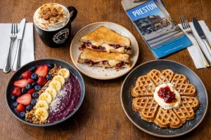 A selection of food and drinks from Black Sheep Coffee Preston including latte, toastie, and waffle