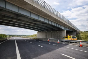 Empty M20 road section under a bridge with maintenance cones near Maidstone, Kent