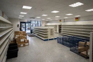 Interior of an empty discount retail store with shelves cleared and boxes stacked